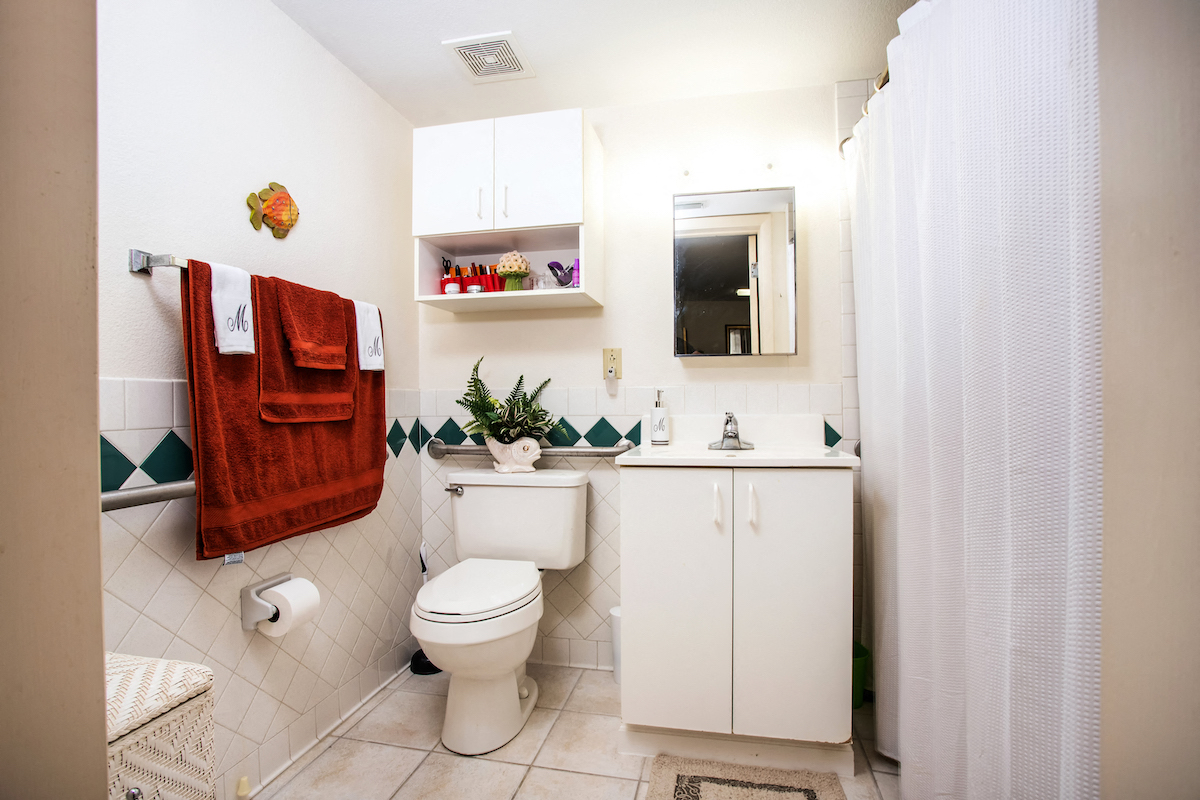 Bathroom with shower, vanity, toilet, and overhead lighting
